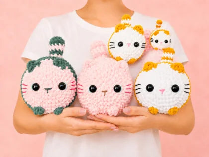 Gatitos amigurumi tejidos a mano sostenidos en las manos