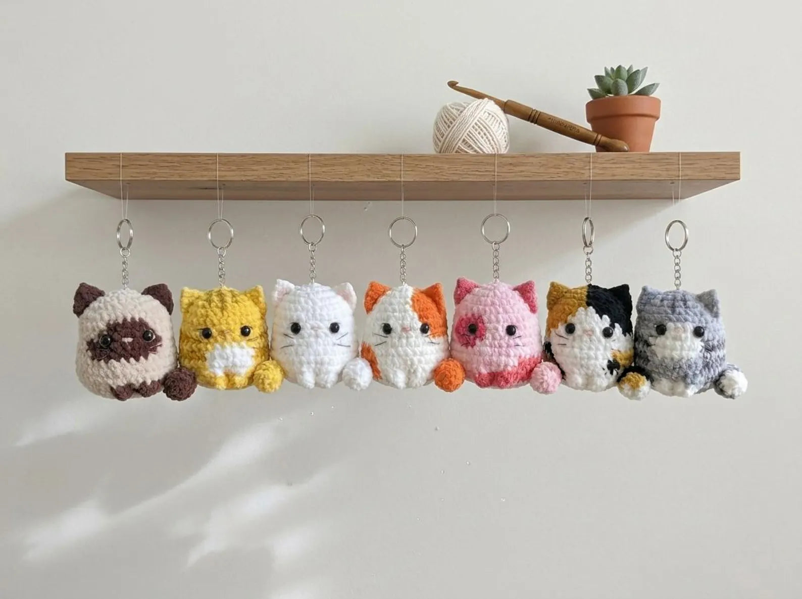 Llaveros de gatitos colgando de una repisa